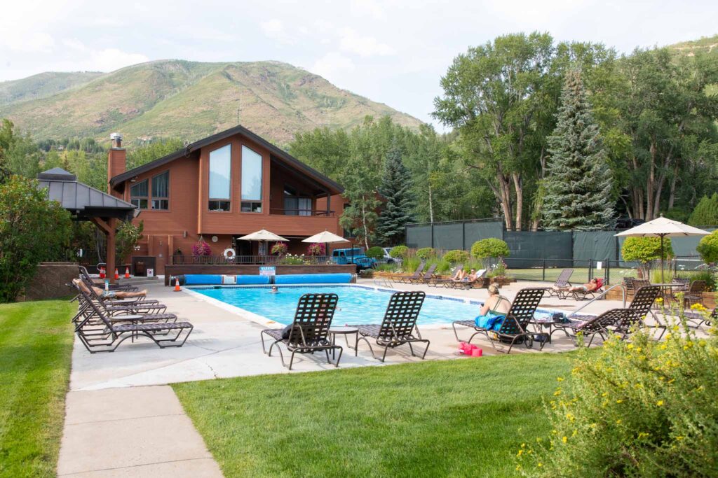 Rear exterior view of Vine development including pool, chairs, and awning