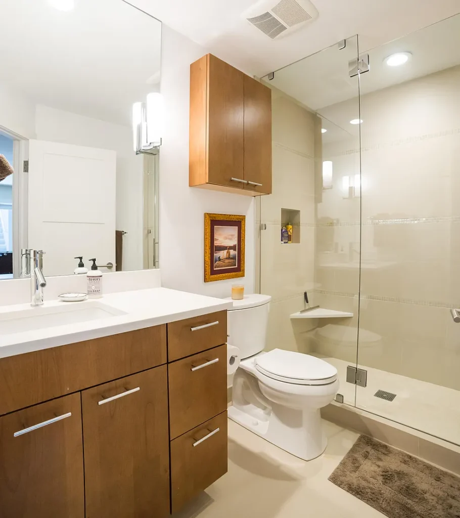 Interior view of Golf Lane bathroom with tempered glass shower and wooden cabinets