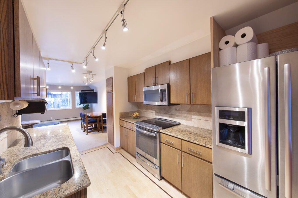 Interior kitchen view at angle towards oven with overview of dining area at Vine development