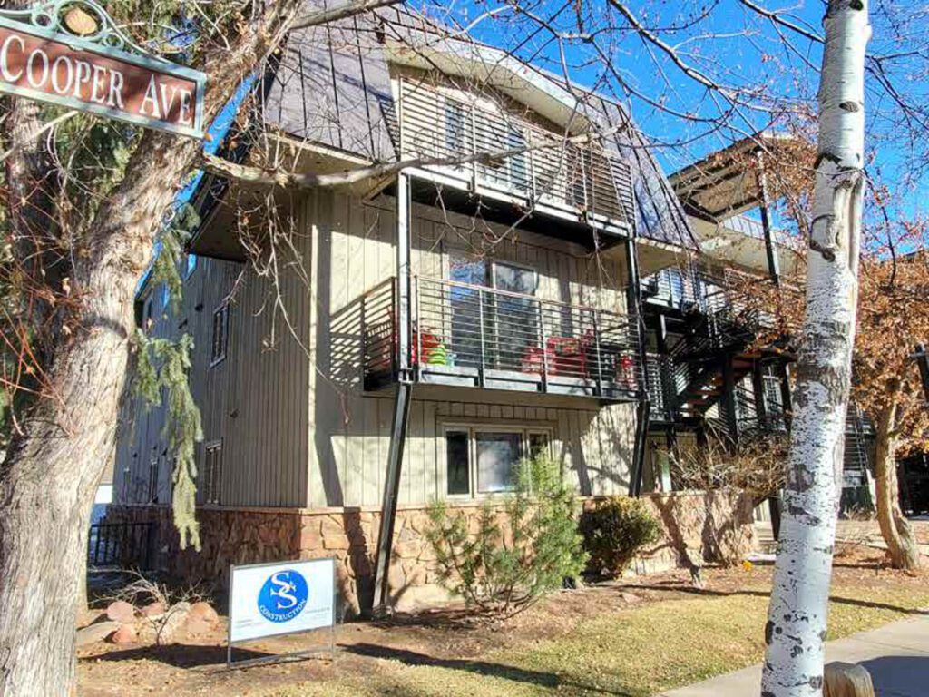 Front exterior view of Cooper Ave with name sign reading Cooper Ave and S and S construction sign