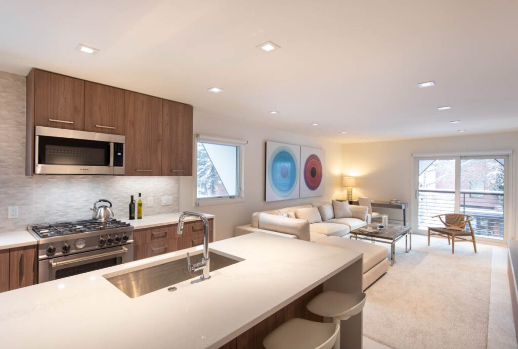 Interior view of kitchen and living room area with large bright windows at Cooper Ave