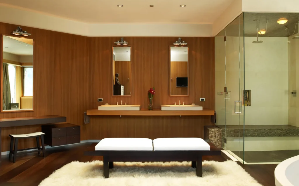 Interior bathroom view angled toward sinks, seating area and glass walled shower at Smuggler Mountain Residence